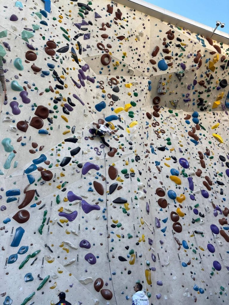 Copil beneficiar Climb Again progresând prin escaladă terapeutică alături de instructor