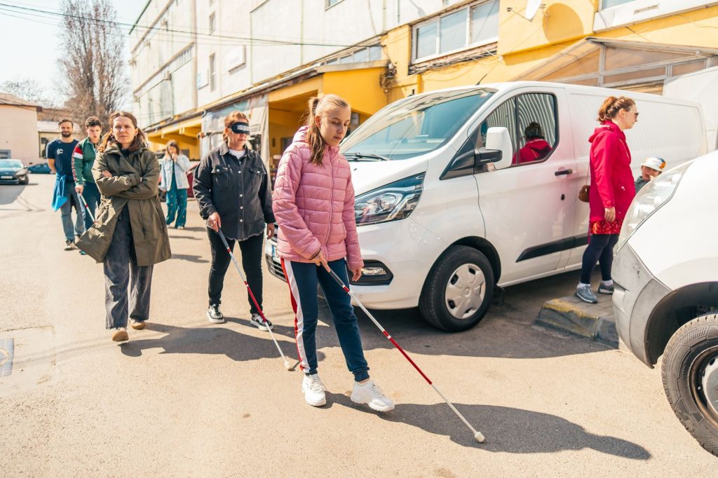 Sportiv din programul terapeutic exersând mișcările de escaladă cu ham și echipament de siguranță