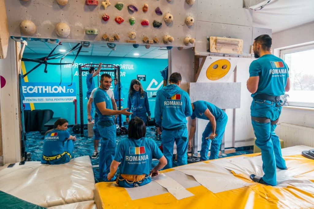 Copil în terapie prin escaladă la antrenamentul de escaladă terapeutică alături de instructor